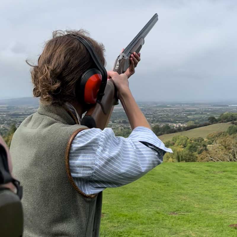 Guest shooting clay pigeons with instructor on the private Farncombe range