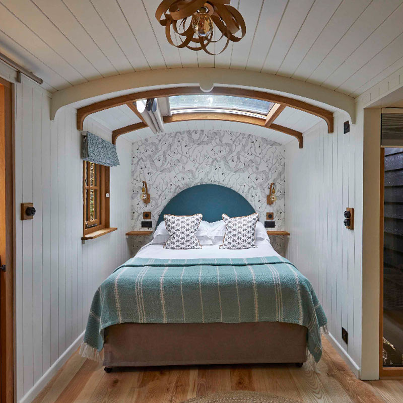 Interior of Hideaway Hut showing wood burning stove and roll top bath in bedroom