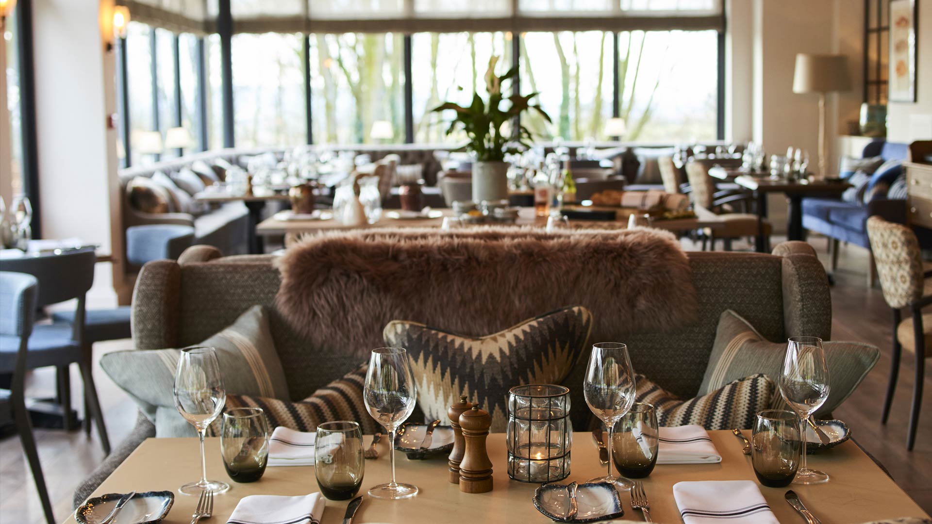 Main dining room of Hook restaurant set with crisp linen and warm Cotswold lighting