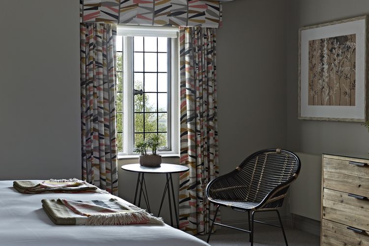 Scandinavian style interior design in The Fish Hotel bedroom overlooking Cotswold landscape