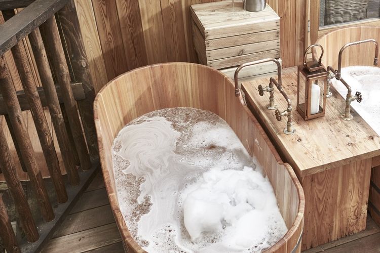 Twin heated outdoor bathtubs on the timber deck of the luxury treehouse