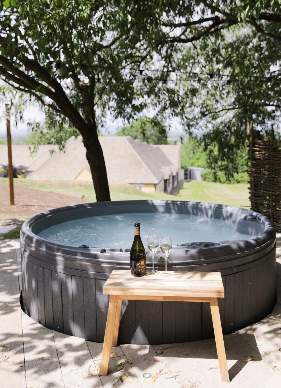 Outdoor hot tub on the terrace of The Hoot overlooking rolling Cotswold hills